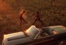 A bird's eye view of the 2 main characters from Wild at Heart dancing in the dusk beside their convertable.